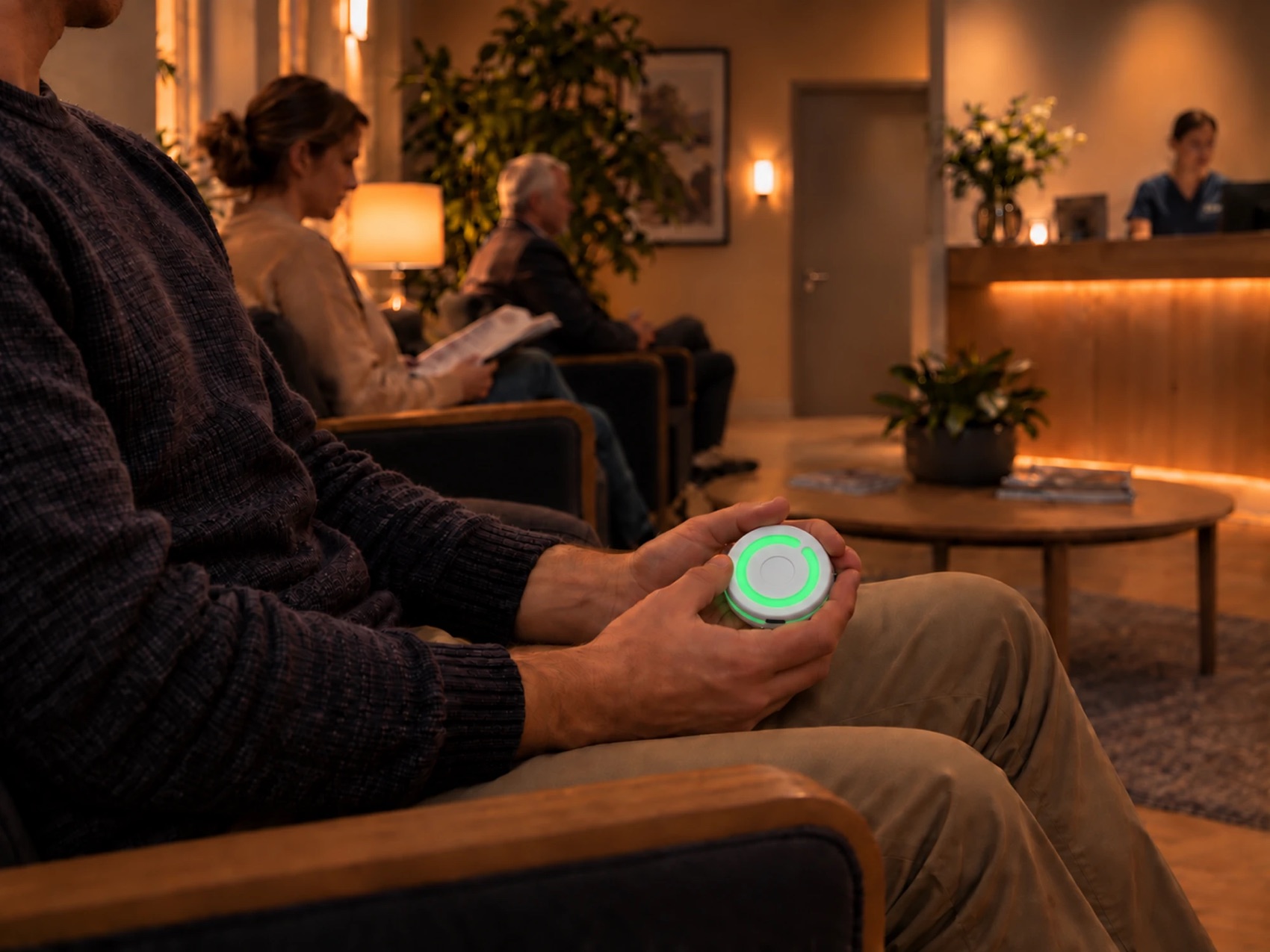 Wartezimmer einer Arztpraxis: Eine wartende Person hält einen grün leuchtenden BusyDot in der Hand.